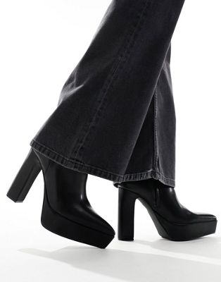 platform heeled boots with pointed toe in black faux leather