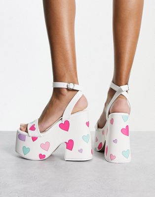 platform heeled sandals in white with heart print