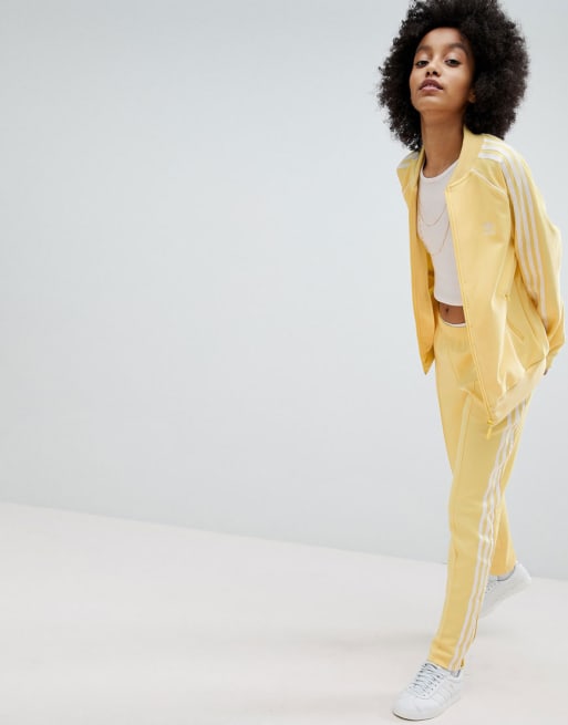 adidas Originals – Adicolor – Gul träningsjacka och -byxor med tre ränder 