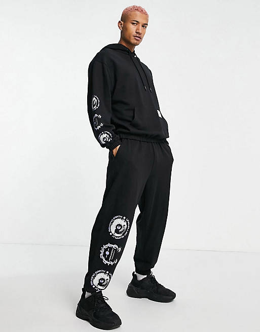 ASOS Unrvlld Spply co-ord oversized joggers with woven tab and graphic print in black