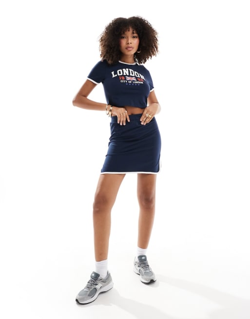 Conjunto azul marino y blanco de minifalda y camiseta corta con texto 