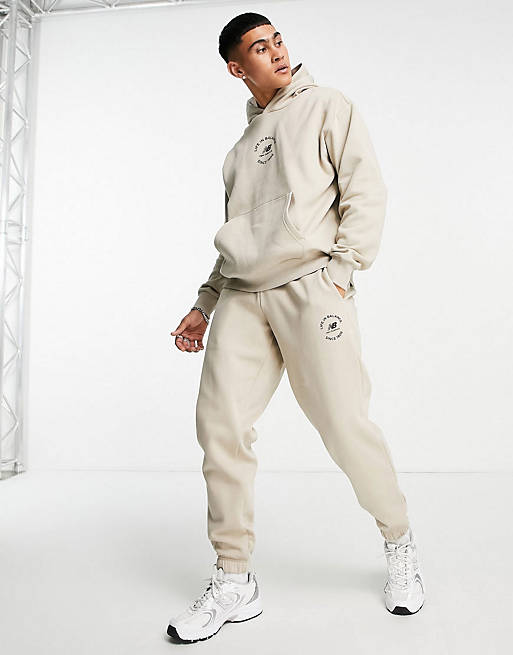Hombre Joggers de ropa deportiva | Conjunto color avena de sudadera, sudadera con capucha, joggers y camiseta Life in Balance de New Balance - HZ43896
