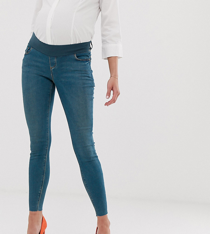 ASOS DESIGN Maternity Ridley high waisted skinny jeans in aged wash blue with raw hem with under the bump waistband