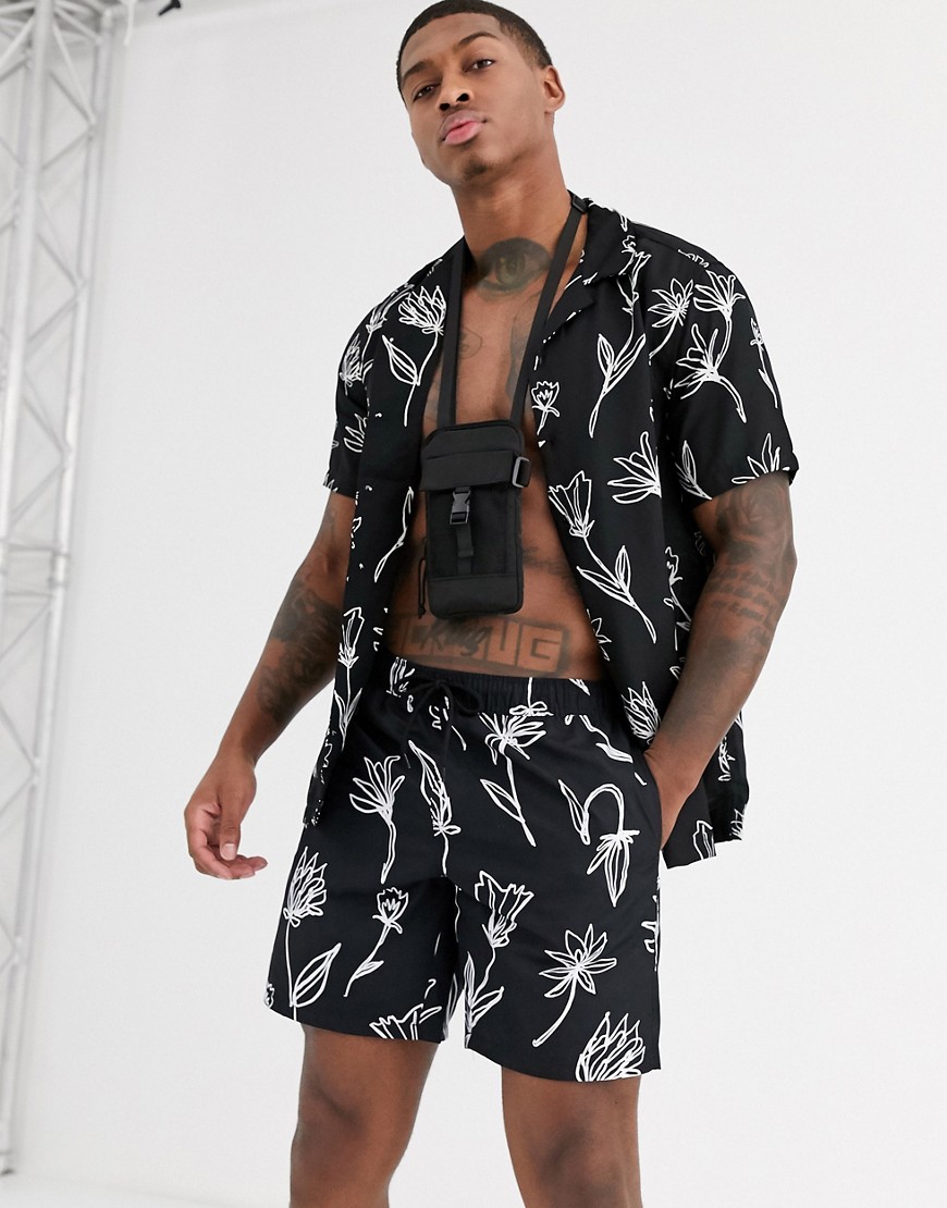 ASOS DESIGN co-ord swim shorts in black with hand drawn floral print in mid length