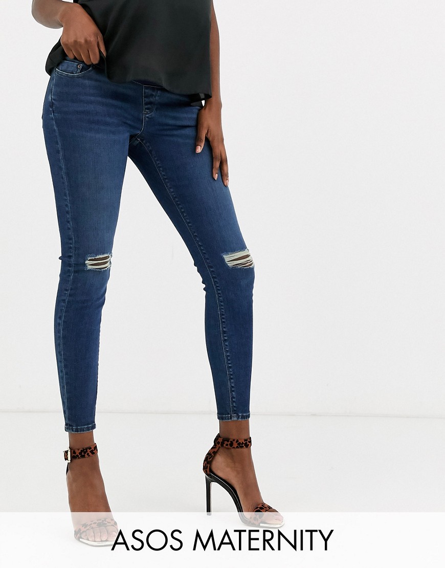 ASOS DESIGN Maternity high rise ridley 'skinny' jeans in dark stonewash blue with busted knee with under the bump waist