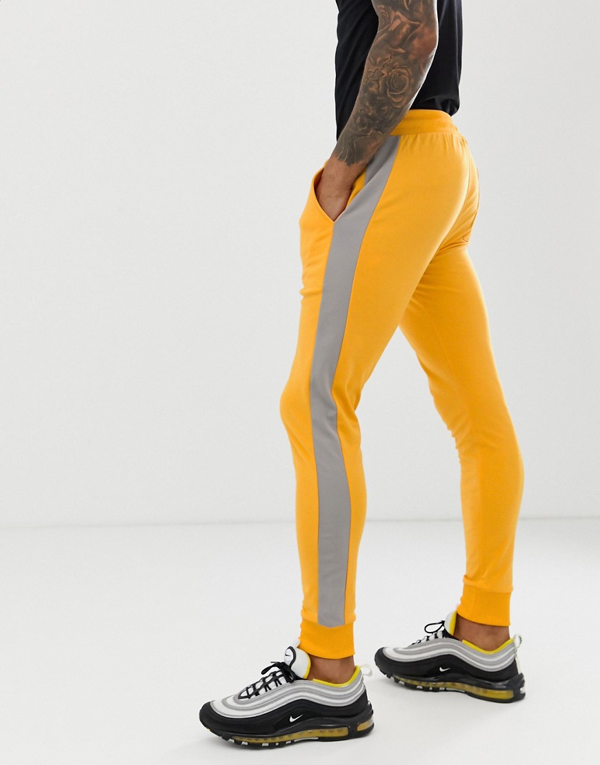 ASOS DESIGN skinny joggers in poly tricot with side stripe in yellow