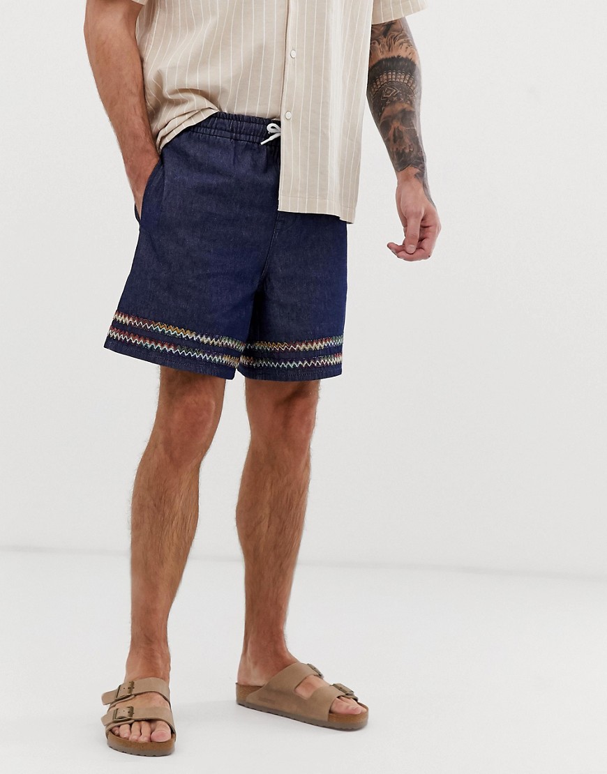 ASOS DESIGN denim shorts with printed tape in indigo