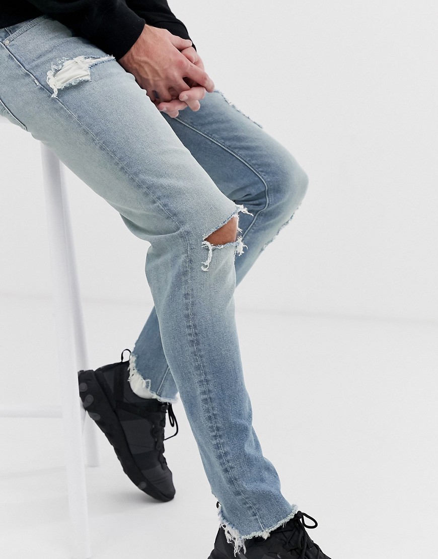 ASOS DESIGN skinny jeans in light wash blue with heavy rips