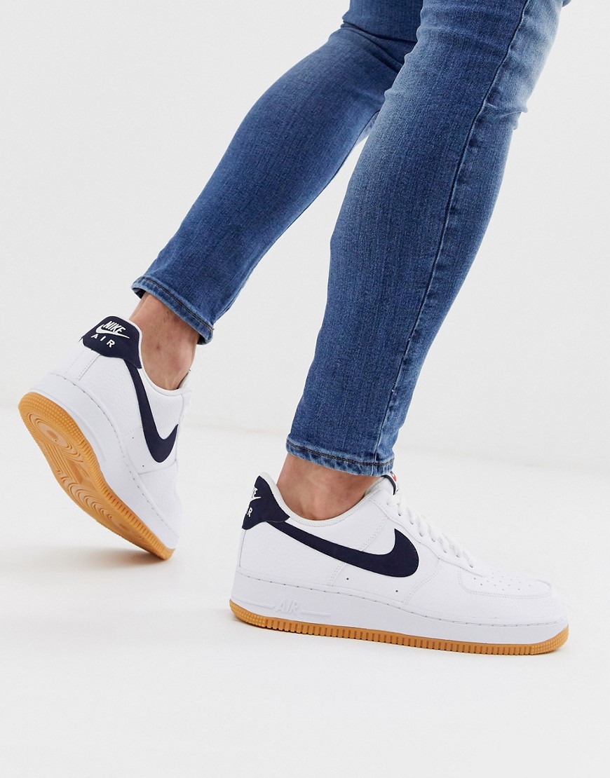 Nike Air Force 1 trainers with navy swoosh and gum sole