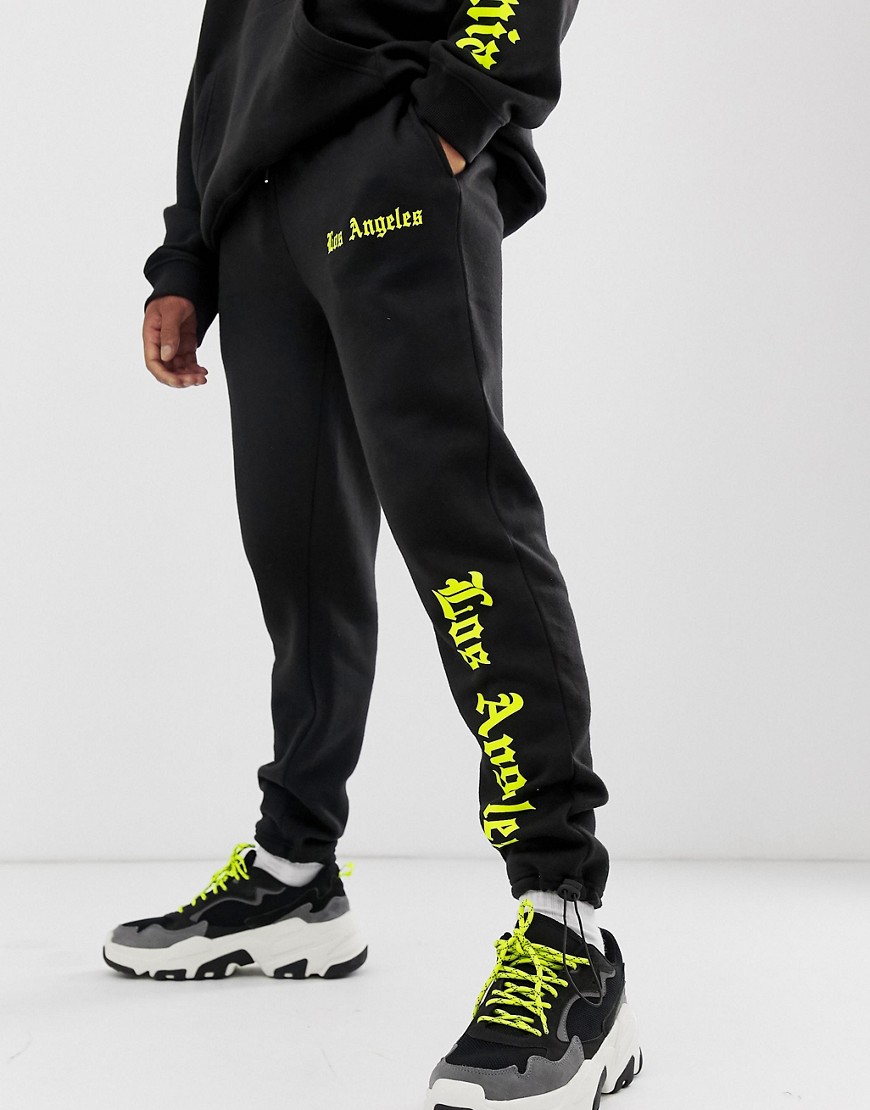 boohooMAN joggers with neon Los Angeles print in black