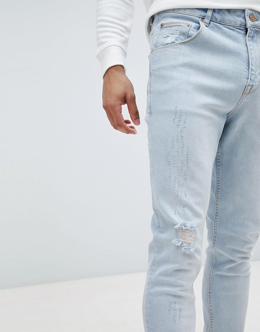 Asos Design Asos Tapered Jeans In Light Wash Blue With Abrasions - Blue