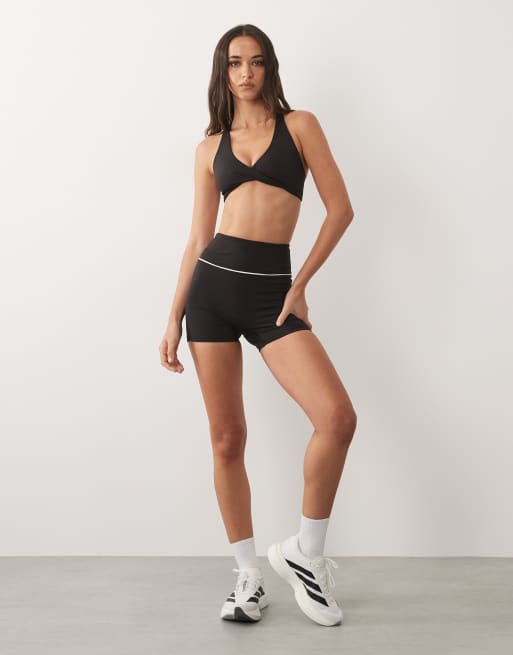 4505 - Conjunto deportivo negro de pantalones cortos de 8 cm ajustados con detalle de ribetes y sujetador deportivo de sujeción ligera con detalle retorcido en la parte delantera