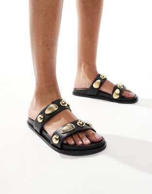 4th & Reckless - Flache Sandalen in Schwarz mit goldener Muschelverzierung und zwei Riemen