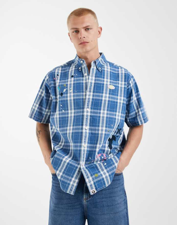 Aape By A Bathing Ape® camisa de manga corta a cuadros en azul y blanco con bajo salpicado