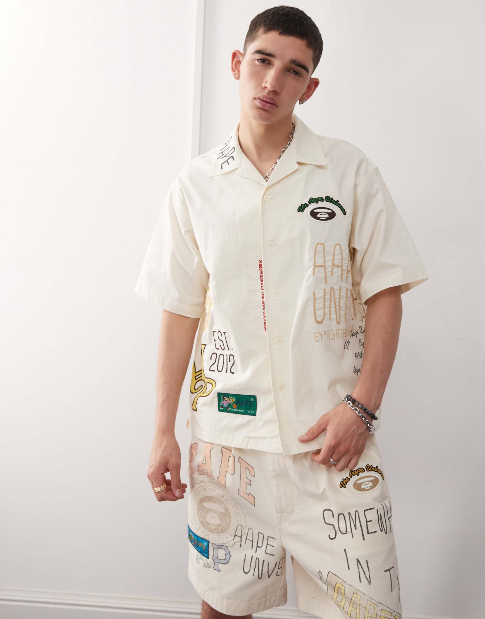 Бежевая рубашка с коротким рукавом Aape By A Bathing Ape с несколькими логотипами колледжа