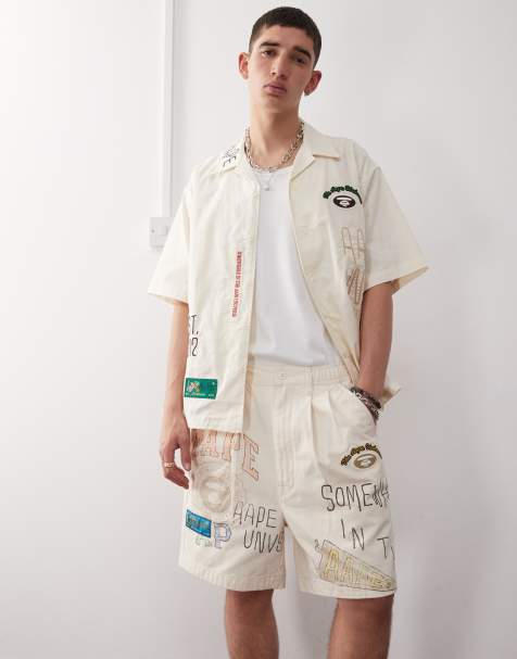 Aape by A Bathing Ape multi logo college shorts in beige - view 1