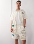 [AAPE BY A BATHING APE®] Aape by A Bathing Ape multi logo college shorts in beige-Neutral M BEIGE