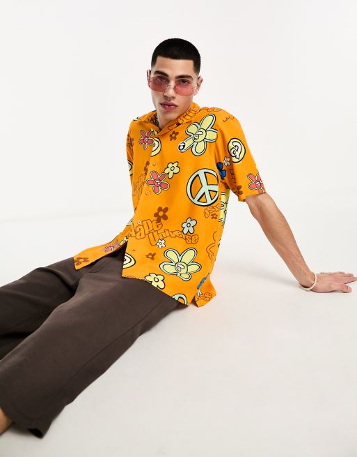 AAPE By A Bathing Ape – Pomarańczowa koszula z krótkim rękawem we wzór w znaki pokoju