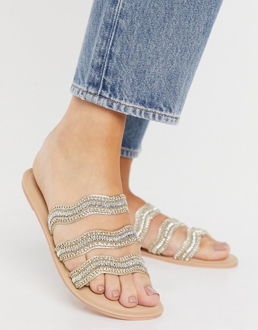Accessorize embellished sandals with wavey straps in gold