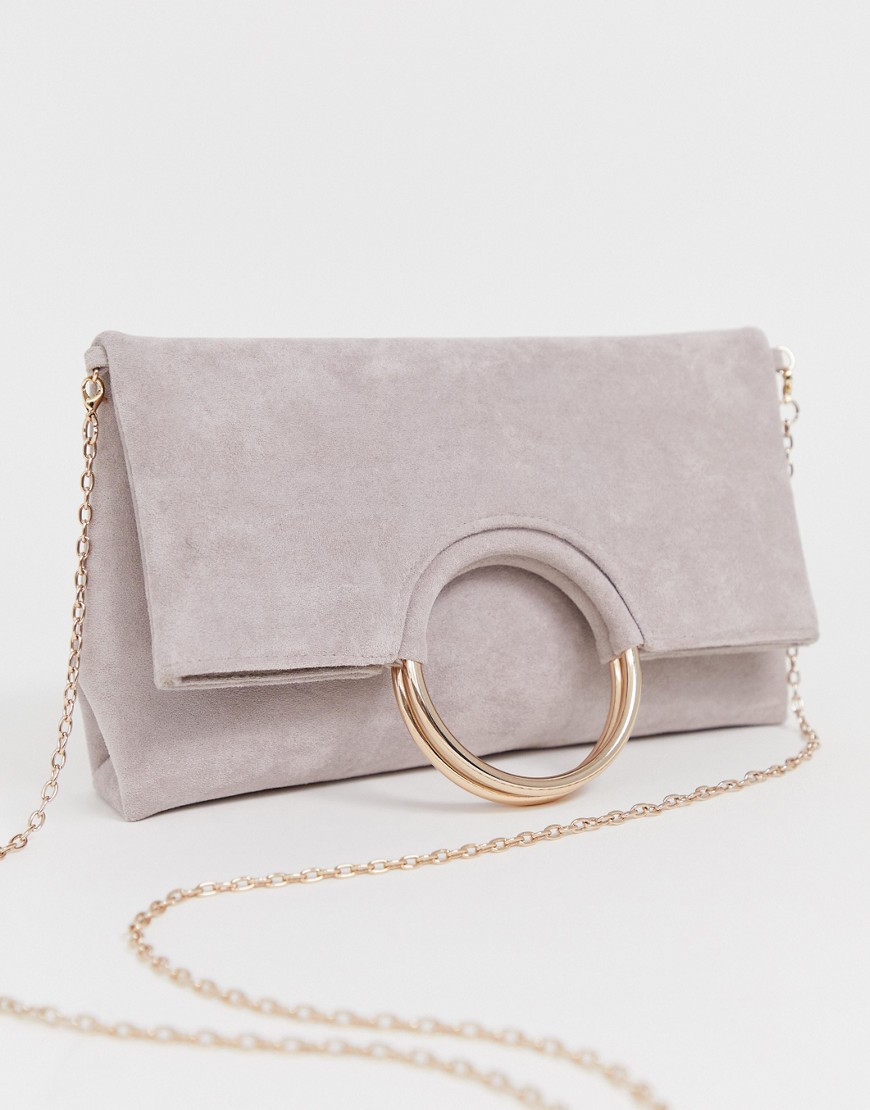 Accessorize foldover pink clutch with metal handle detail and removable chain strap