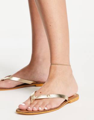Accessorize leather flip flops in gold metallic | ASOS