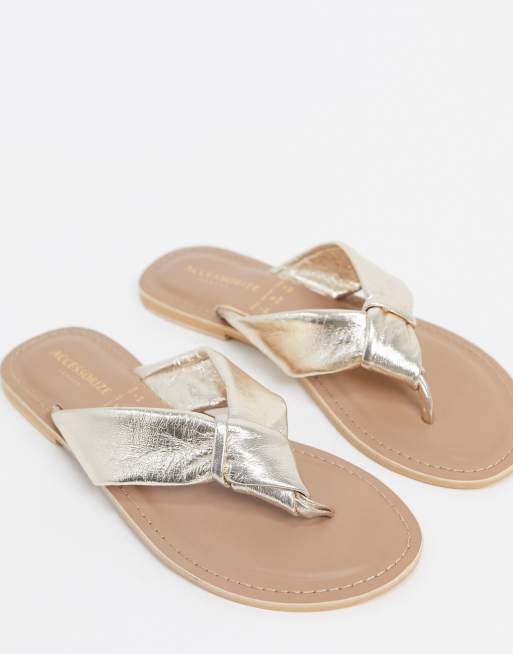 Accessorize leather knotted flip flops in rose gold | ASOS