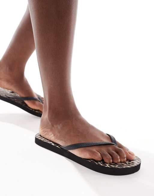 Accessorize leopard print thongs in black