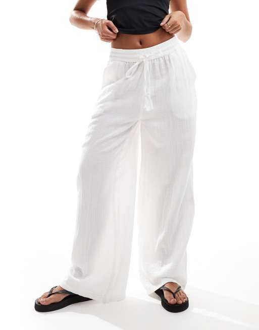 Accessorize wide leg beach pants in white