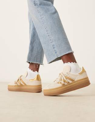adidas Orginals Gazelle Bold trainers in off white and metallic gold stipes