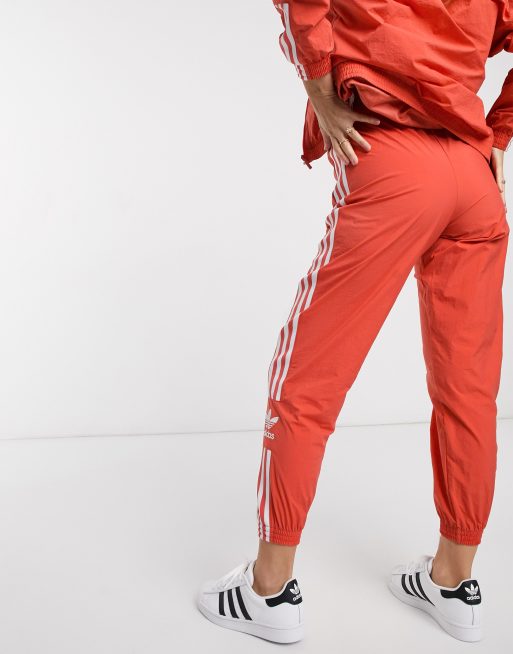 adidas Originals adicolor locked up logo track pants in coral