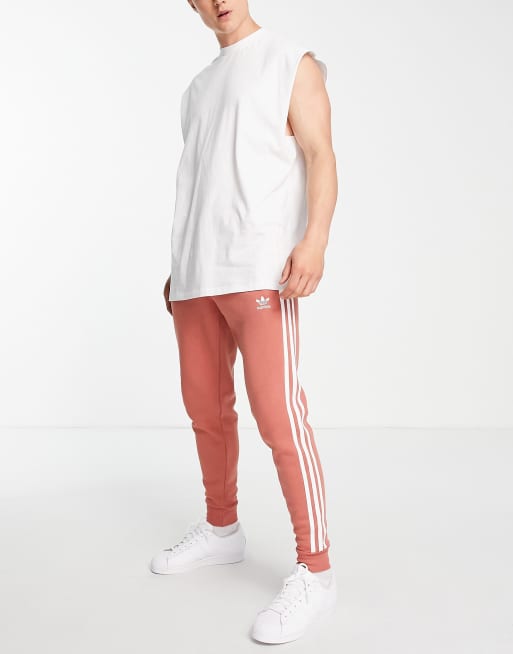adidas Originals Adicolor Schmal geschnittene Jogginghose in Orange mit den 3 Streifen und Dreiblatt Logo ASOS