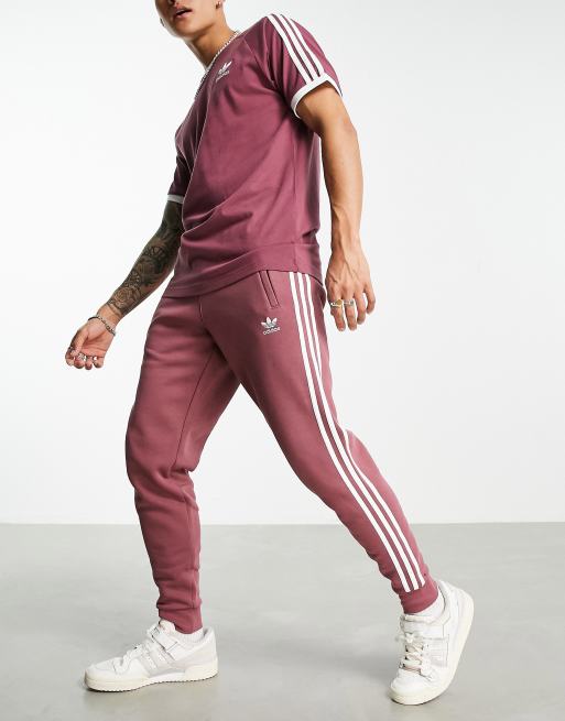 adidas Originals adicolor three stripe trackies in quiet crimson
