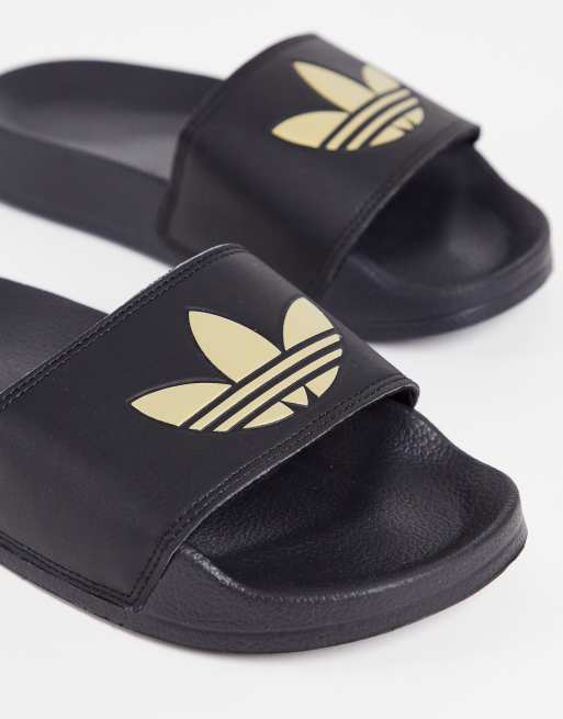 adidas Originals Adilette lite sliders in black with gold trefoil