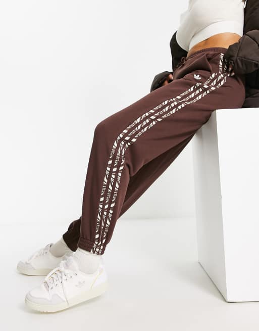 adidas Originals – Animal Abstract – Brązowe joggersy z trzema paskami i wzorem w zeberkę