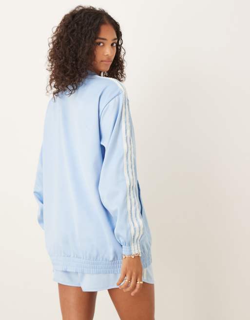 adidas Originals satin track top in blue with ruffle 3 stripe