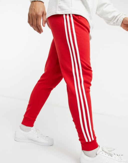 adidas Originals three stripe joggers in red