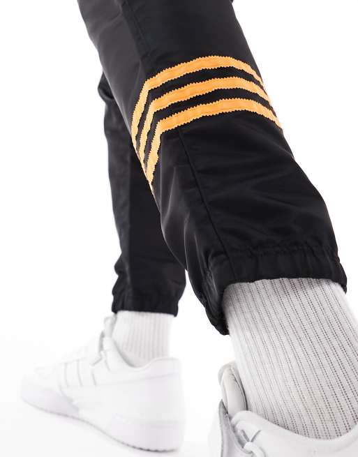 NEUCLASSICS+ トラックパンツ ブラック×セミインパクトオレンジ