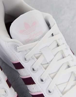 white adidas with pink stripes