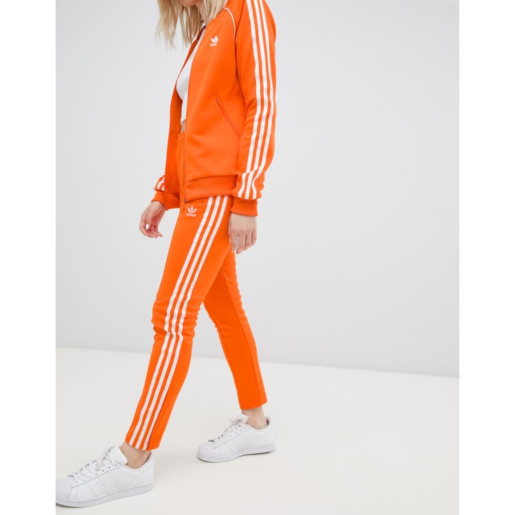 Adidas Originals Pantaloni a sigaretta arancioni con tre strisce