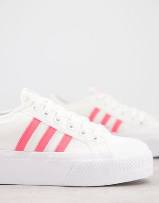 white adidas with pink stripes