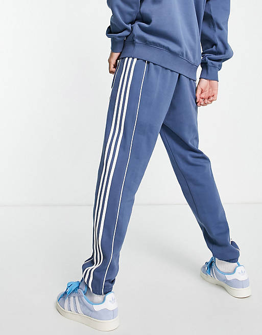 adidas Originals – Rekive – Jogginghose mit den drei Streifen in Blau | ASOS