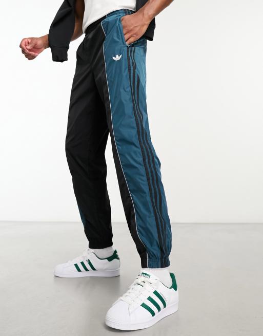 adidas Originals – Rekive – Svart och blå träningsbyxor med meshdetaljer