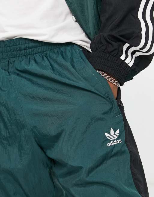 adidas Originals Rekive woven track pants in light green with graphic detail