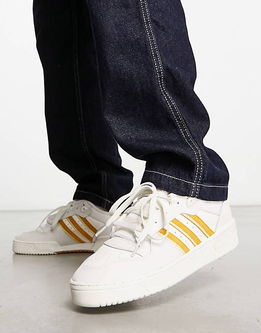 adidas Originals Rivalry Low trainers in white/gold | ASOS