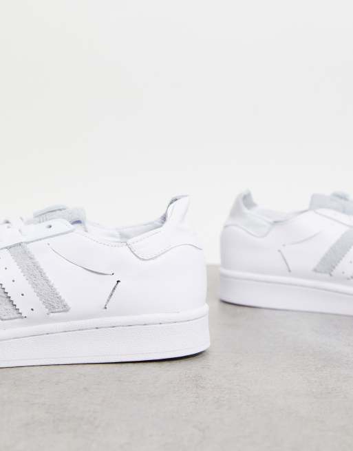 adidas Originals Superstar minimalist trainers in white with grey stripes