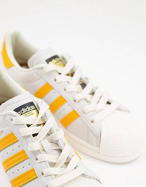 adidas Originals – Superstar – Sneaker in Weiß und Gelb | ASOS