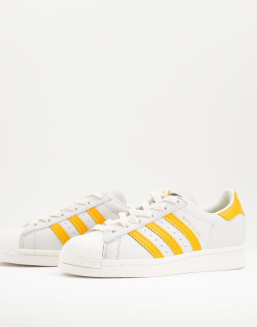adidas Originals Superstar sneakers in white and yellow