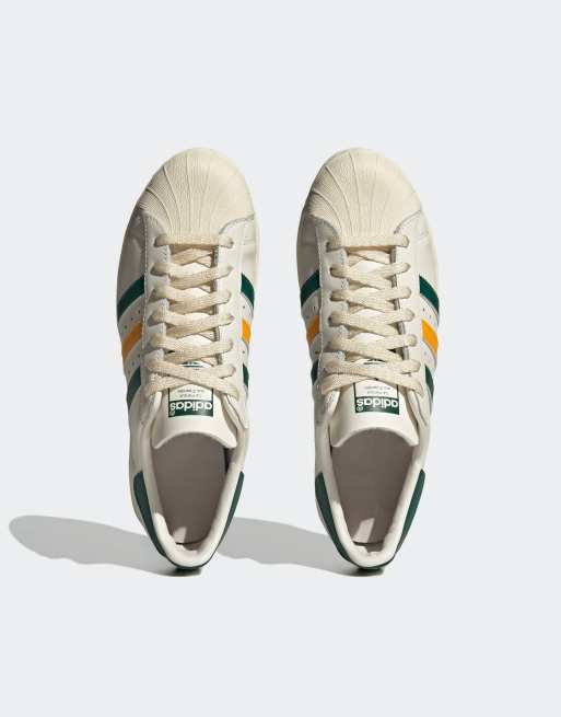 adidas Originals Superstar trainers in white and green with yellow stripes