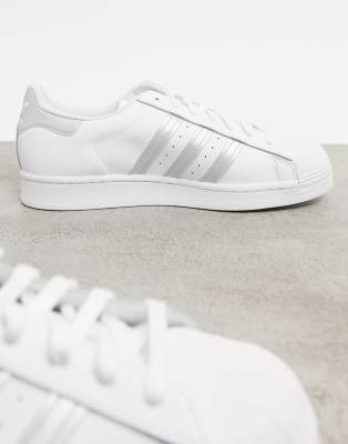 white adidas with silver stripes