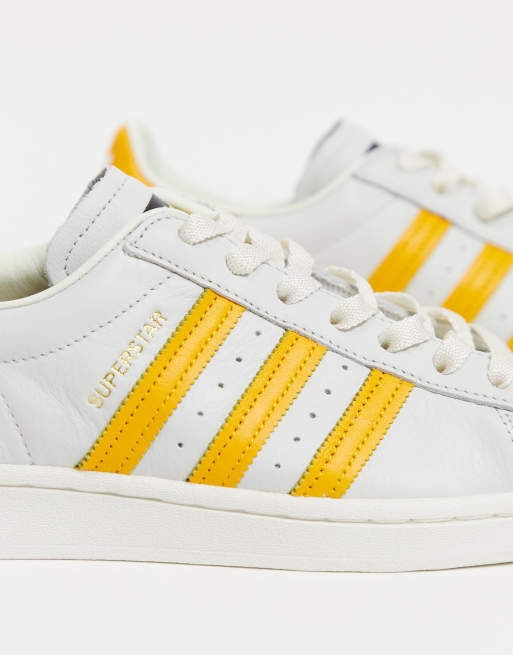 adidas Originals Superstar trainers in white with yellow stripes